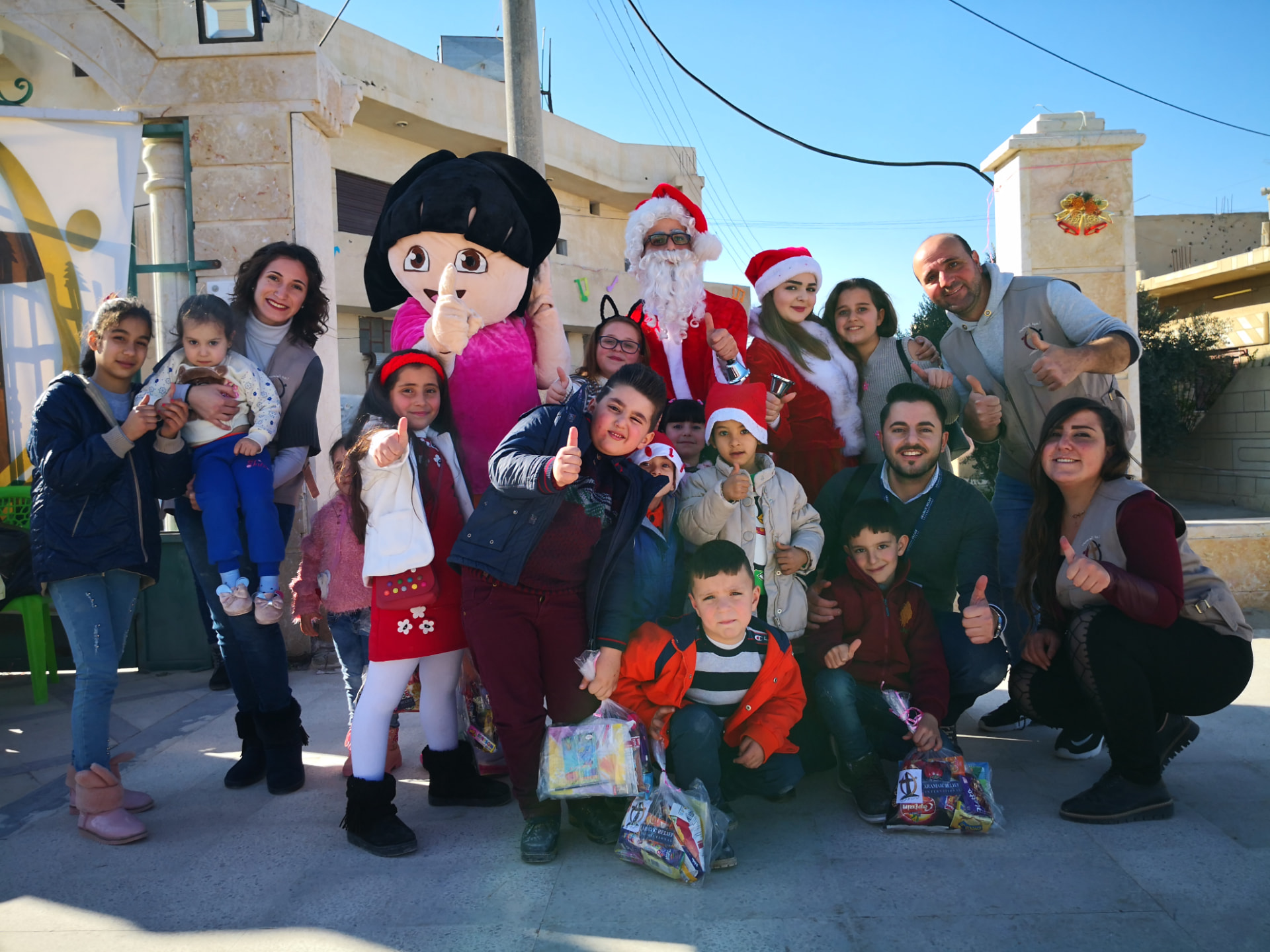 Kinder und Helfende bei einer Weihnachtsaktion von Aramaic Relief International
